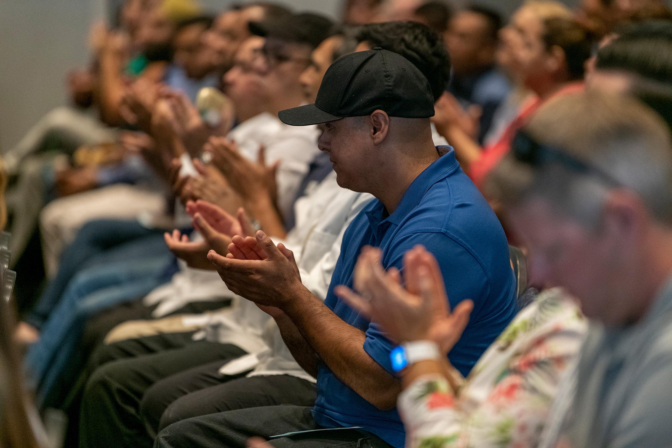 staff clapping in the audience at town hall