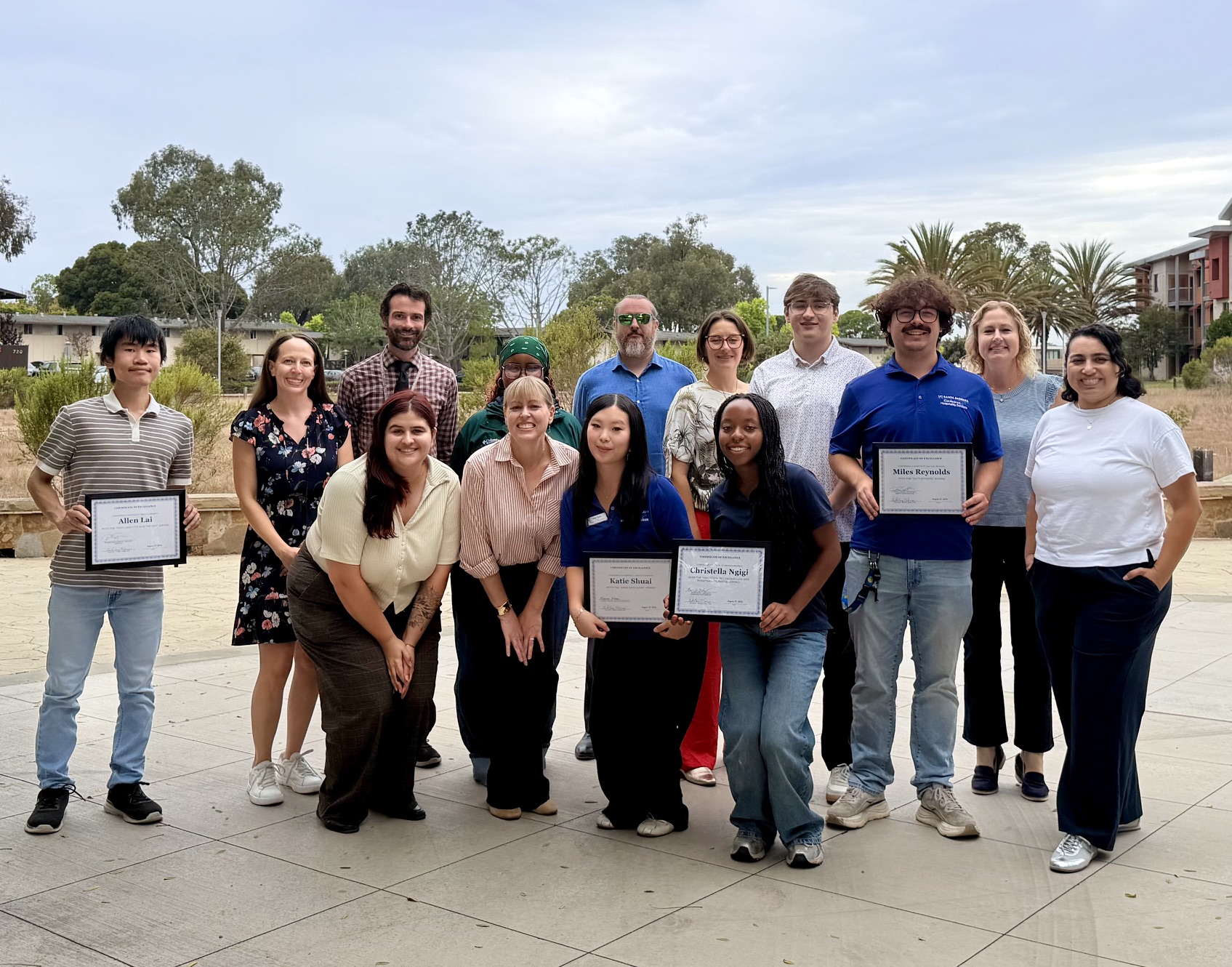 Group of staff members posing with certificates