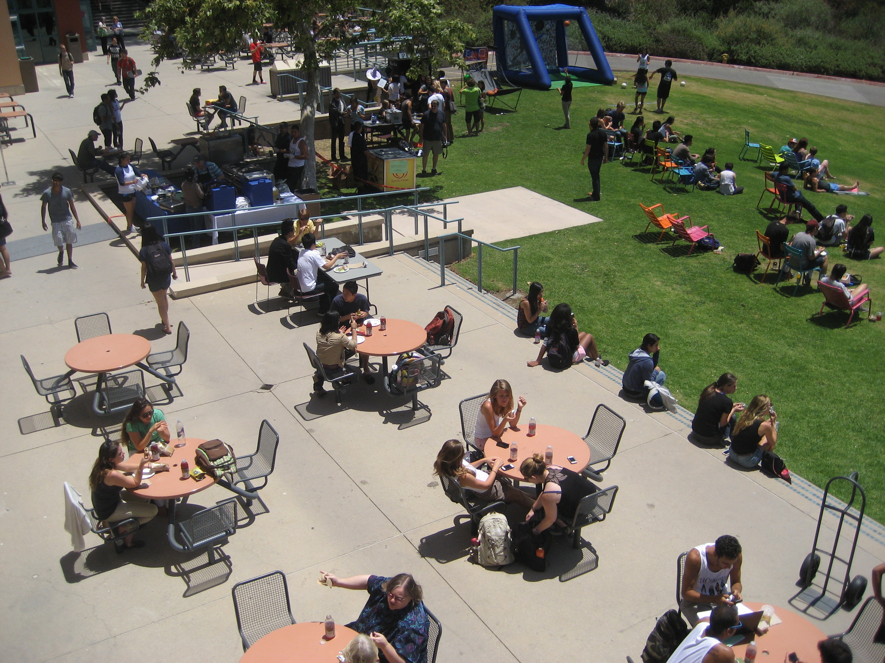 Aerial view of a patio with students sitting at tables.
