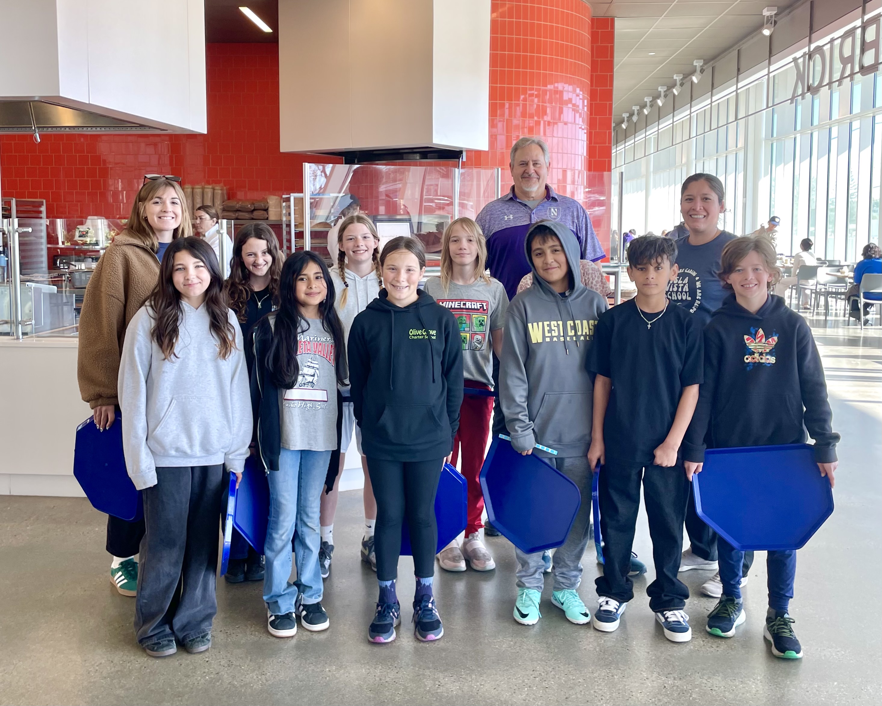 A group of sixth graders inside a large, open dining commons