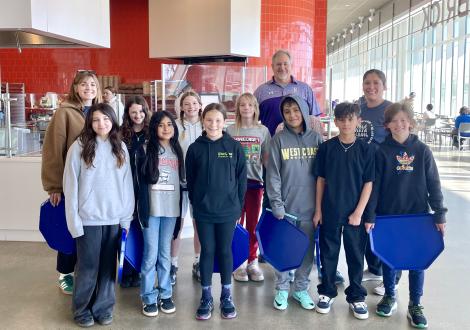 A group of sixth graders inside a large, open dining commons