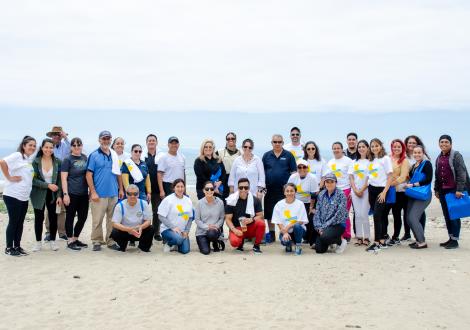 Group photo of UCSB employees on the beach with the oean in the background