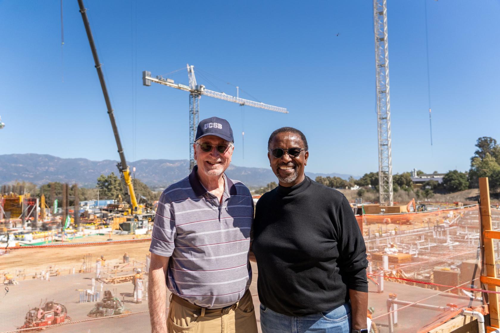 two men standing in front of a construction site